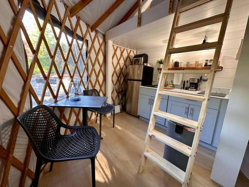 a small kitchen with a table and a ladder in a room at Purple City Retreats - Luxury Yurt & Spa in Portland