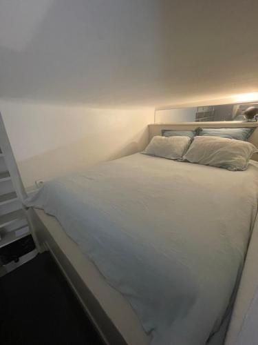 - un lit blanc avec deux oreillers dans l'établissement Élégant studio avec mezzanine porte des Ternes, à Paris