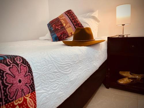 a hat is sitting on top of a bed at Hotel Camoruco in Yopal