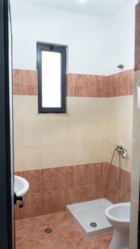a bathroom with a sink and a toilet and a window at Villa ReyAn Durrës in Durrës