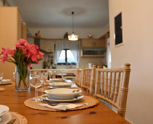 a dining room table with a vase of flowers on it at Aurora Spinalonga Garden Cottage in Chavgas