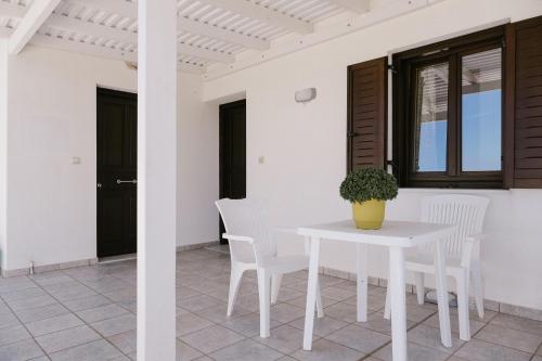 a white table and chairs in a room with a window at Iliachtida apartments in Philotium