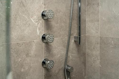 a shower with a shower head in a bathroom at Hotel BLU in Vancouver