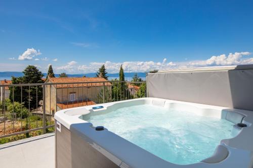 a hot tub on a balcony with a view at Apartmani Vila Mara M 4 heated pool and whirpool in Omišalj