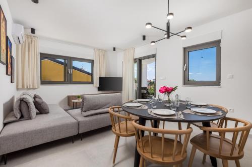 a living room with a table and a couch at Apartmani Vila Mara M 4 heated pool and whirpool in Omišalj