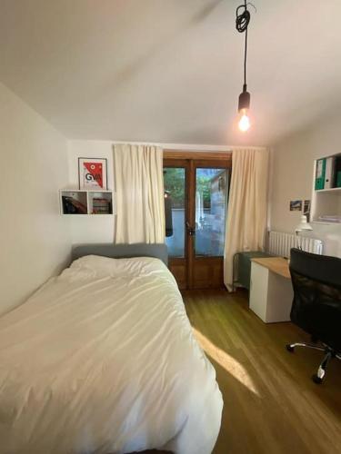 une chambre avec un lit, un bureau et une chaise dans l'établissement Grand appartement T4, vue unique lac, terrasse et spa, à Annecy-le-Vieux