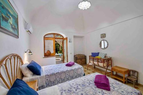 a living room with two beds and a mirror at Monicas garden and the Sea in Praiano