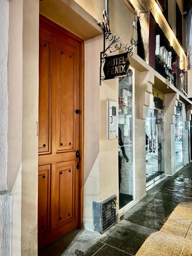 a store front with a wooden door and a window at Hotel Fenix in Ocaña