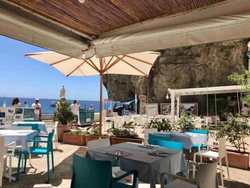 a restaurant with tables and chairs and an umbrella at Monicas garden and the Sea in Praiano