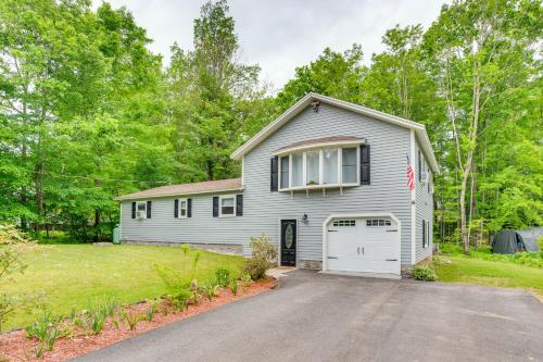 a white house with a garage and a driveway at Quiet New Hampshire Getaway with Game Room! in Center Barnstead