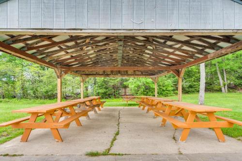 a group of wooden picnic tables in a park at Quiet New Hampshire Getaway with Game Room! in Center Barnstead
