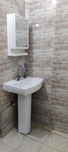 a bathroom with a sink and a mirror on a wall at Shree Bankebihari Niwas in Vrindāvan