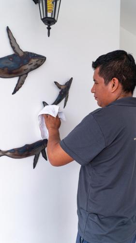 a man is putting birds on a wall at Hotel Galapagos Suites B&B in Puerto Ayora