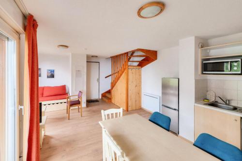 une cuisine et un salon avec une table et des chaises dans l'établissement Résidence Les Chalets de Puy Saint Vincent - maeva Home - Appartement 3 Pièces 6 Personnes - Confort MAE-6380, à Narreyroux