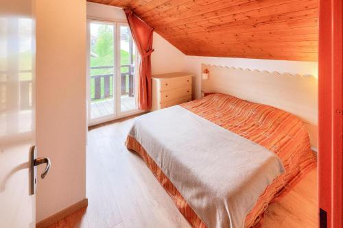 une chambre avec un lit et une grande fenêtre dans l'établissement Résidence Les Chalets de Puy Saint Vincent - maeva Home - Appartement 3 Pièces 6 Personnes - Confort MAE-6380, à Narreyroux