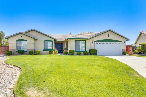 a house with a large yard with a driveway at Victorville Home with Large Yard and Charcoal Grill! in Victorville