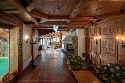 sala de estar con techo de madera y chimenea en Hotels am Kranichsee, en Hahnenklee-Bockswiese