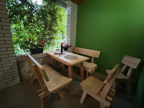 a table and chairs in a room with a green wall at Apartman Maša in Belo Blato