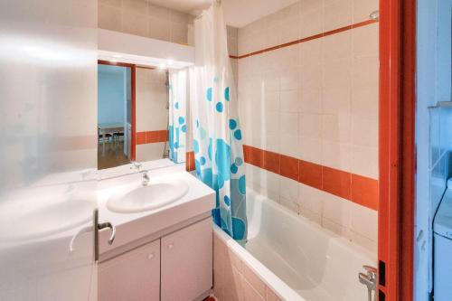 bagno con lavandino e vasca di Résidence Les Chalets de Puy Saint Vincent - maeva Home - Appartement 2 Piè 51 a Narreyroux