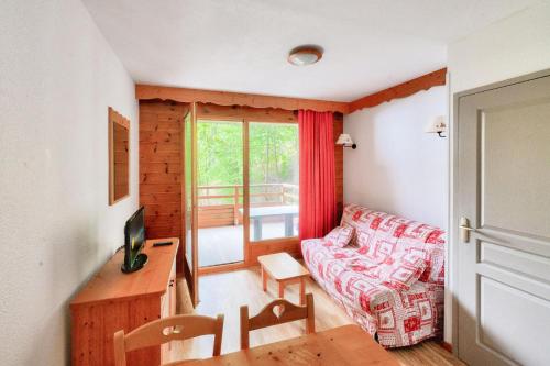 un salon avec un canapé et une table dans l'établissement Résidence Le Hameau des Ecrins - maeva Home - Appartement 2 Pièces 4 Personnes - Confort MAE-6158, à Puy-Saint-Vincent