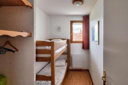 une petite chambre avec deux lits superposés et une fenêtre dans l'établissement Résidence Les Gentianes - maeva Home - Appartement Confort 2 chambres (6 personnes) MAE-6202, à Puy-Saint-Vincent