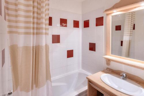 une salle de bain avec une baignoire blanche et un lavabo dans l'établissement Résidence Les Gentianes - maeva Home - Appartement Confort 2 chambres (6 personnes) MAE-6202, à Puy-Saint-Vincent