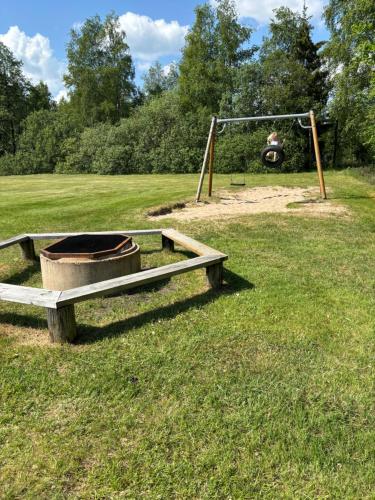a park with a playground with a swing at Gästhus i gårdsmiljö in Forsheda