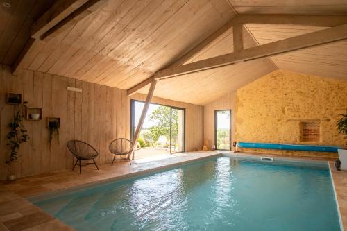 - une piscine dans une chambre dotée d'un plafond en bois dans l'établissement Hameau de Pallanne - Villa de Luxe & Cottages, à Pallanne