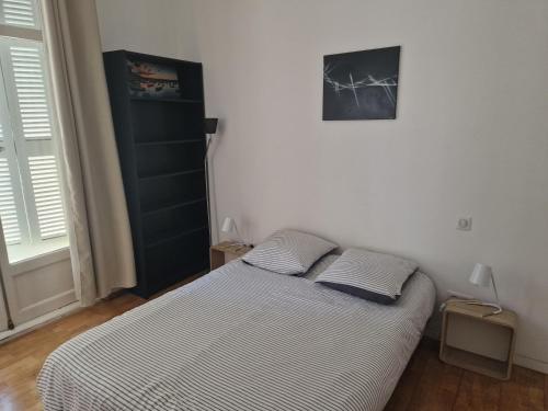 une chambre avec un lit avec deux oreillers dessus dans l'établissement Beautiful and bright 1st Floor Flat with large Terrace - Biarritz City Center, à Biarritz