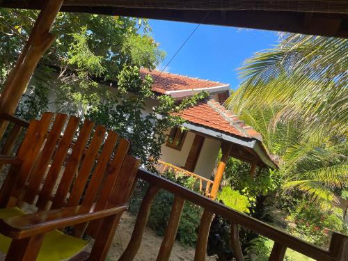 a house with a chair and a palm tree at Prime Surfers Bungalow in Arugam Bay