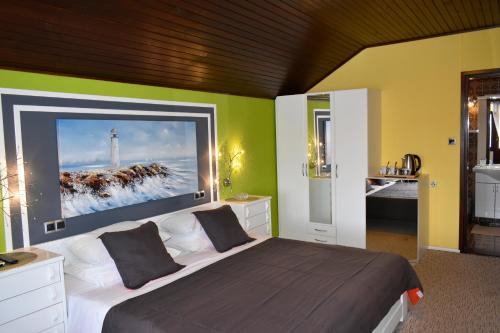 Guesthouse Ema في سوكوشان: غرفة نوم مع سرير مع لوحة كبيرة على الحائط