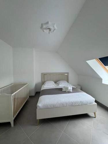 une chambre avec un lit dans une pièce blanche dans l'établissement Maison conviviale, à Mont-près-Chambord