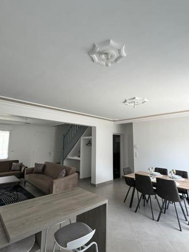 un salon avec un canapé, une table et des chaises dans l'établissement Maison conviviale, à Mont-près-Chambord