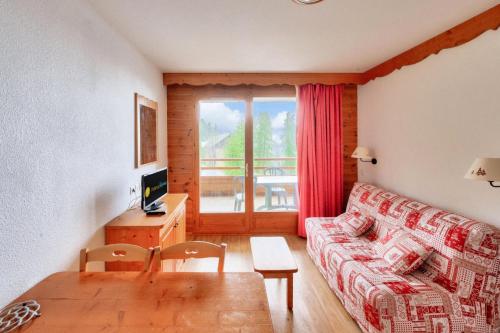 un salon avec un canapé et une table dans l'établissement Résidence Le Hameau des Ecrins - maeva Home - Appartement 2 Pièces 4 Personnes - Confort MAE-7064, à Puy-Saint-Vincent