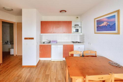 une cuisine et une salle à manger avec une table et des chaises dans l'établissement Résidence Le Hameau des Ecrins - maeva Home - Appartement 2 Pièces 4 Personnes - Confort MAE-7064, à Puy-Saint-Vincent
