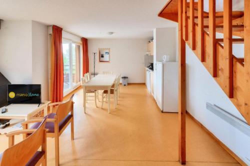 - un salon avec une table à manger et un escalier dans l'établissement Résidence Les Chalets de Puy Saint Vincent - maeva Home - Appartement 3 pièces 6 personnes - Budget MAE-8074, à Narreyroux