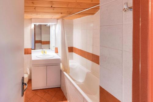 une salle de bain avec une baignoire et un lavabo et une baignoire dans l'établissement Résidence Les Chalets de Puy Saint Vincent - maeva Home - Appartement 3 pièces 6 personnes - Budget MAE-8074, à Narreyroux