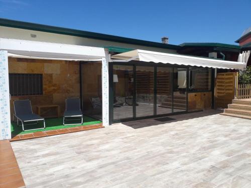 a patio with two chairs and an awning on a house at La Casita de Yuncos in Yuncos