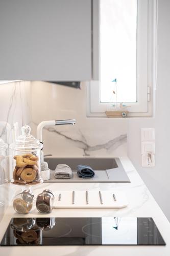 a kitchen with a stove top oven with a sink at Elena Seafront Luxury Apartments in Almirida