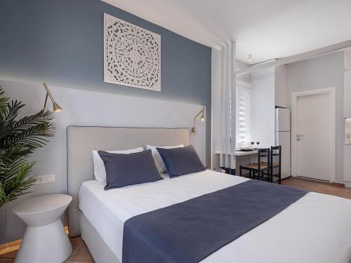 a bedroom with a large bed with blue walls at Elena Seafront Luxury Apartments in Almirida