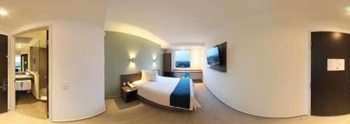 a hotel room with a bed and a bathroom at One Cuautitlan in Cuautitlán