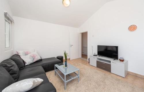 a living room with a black couch and a tv at 2 Bedroom Lovely Apartment In Potocnica in Potocnica