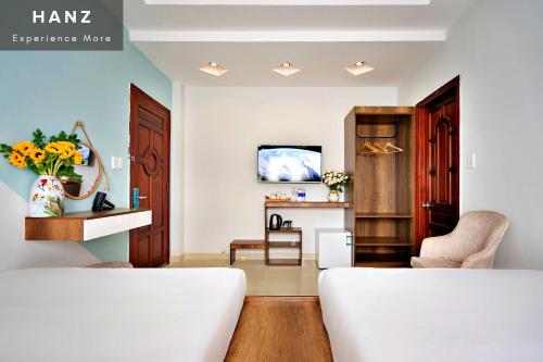 a living room with a white couch and a tv at Thu Khoa Huan Hotel in Ho Chi Minh City