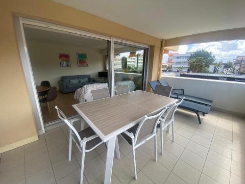 une salle à manger avec une table et des chaises et un salon dans l'établissement Appartement T3 rénové face plage avec terrasse et parking sécurisé - Arcachon - FR-1-374-224, à Arcachon