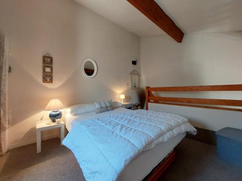 une chambre avec un grand lit avec des draps bleus dans l'établissement Charmante Maisonnette avec Piscine à Proximité du Lac et des Plages de Saint-Palais-sur-Mer - FR-1-550-80, à Saint-Palais-sur-Mer