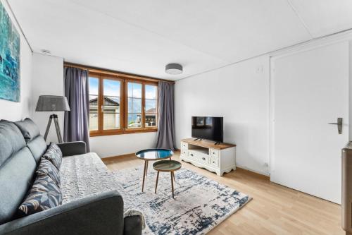 a living room with a couch and a table at App. Seeblick Top of Interlaken in Beatenberg