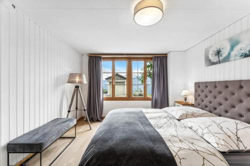 Un dormitorio con una cama grande y una ventana en App. Seeblick Top of Interlaken, en Beatenberg