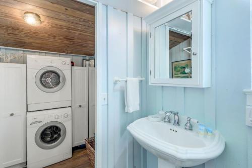 a bathroom with a sink and a washing machine at Roosevelt Cottage in Captiva