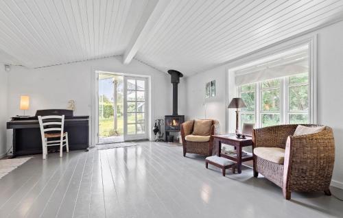 a living room with chairs and a table and a fireplace at Lovely Home In Vejby With Kitchen in Vejby
