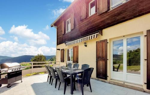 un patio avec une table, des chaises et un barbecue dans l'établissement Lovely Home In Gérardmer With Kitchen, à Gérardmer